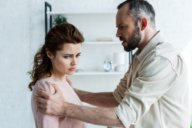 angry man touching offended brunette woman at home Narcissistic Abuse