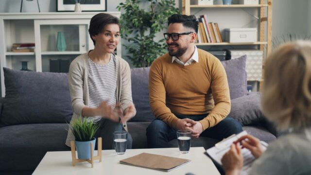 Counselor speaking with a couple in a warm office - christian marriage counseling resources