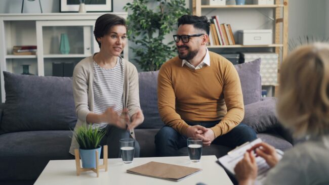 Counselor speaking with a couple in a warm office - christian marriage counseling resources
