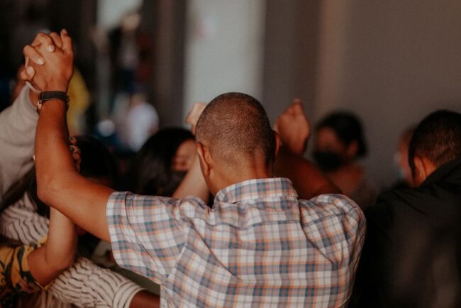 Biblical men's support group praying together in a circle