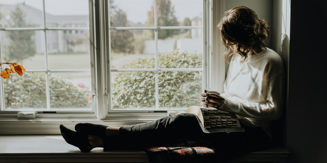 Christian woman by window with Bible