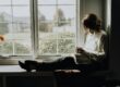 Christian woman by window with Bible