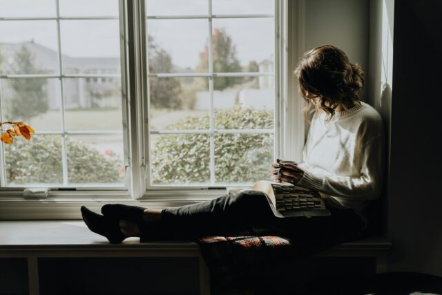 Christian woman by window with Bible